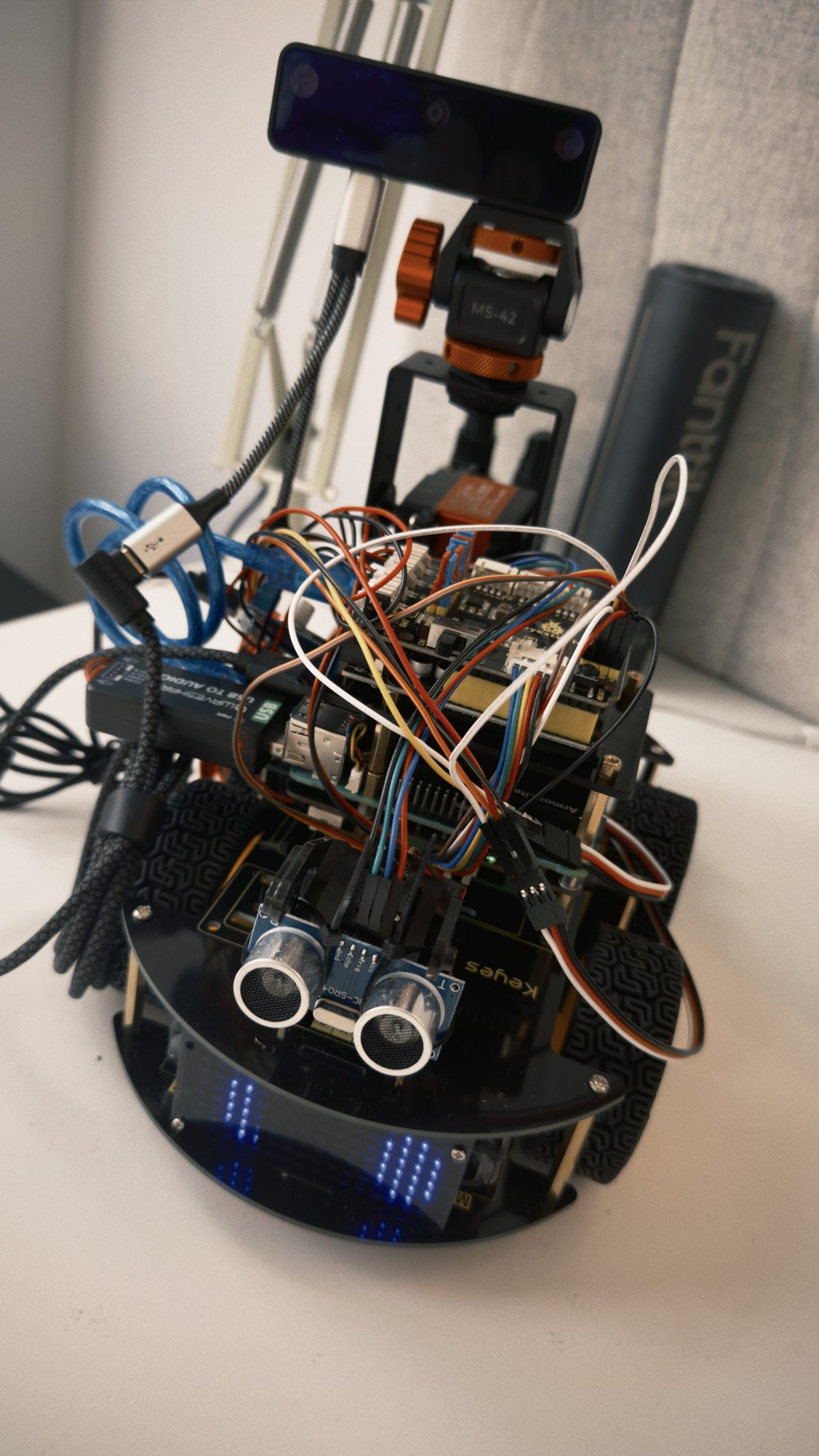 The finished robot: sensors, camera, LED face and a lot of visible wiring